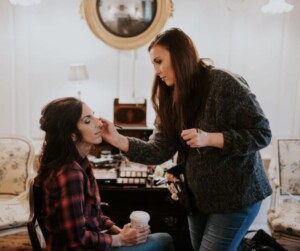 Image of bride getting mascara applied by her makeup artist